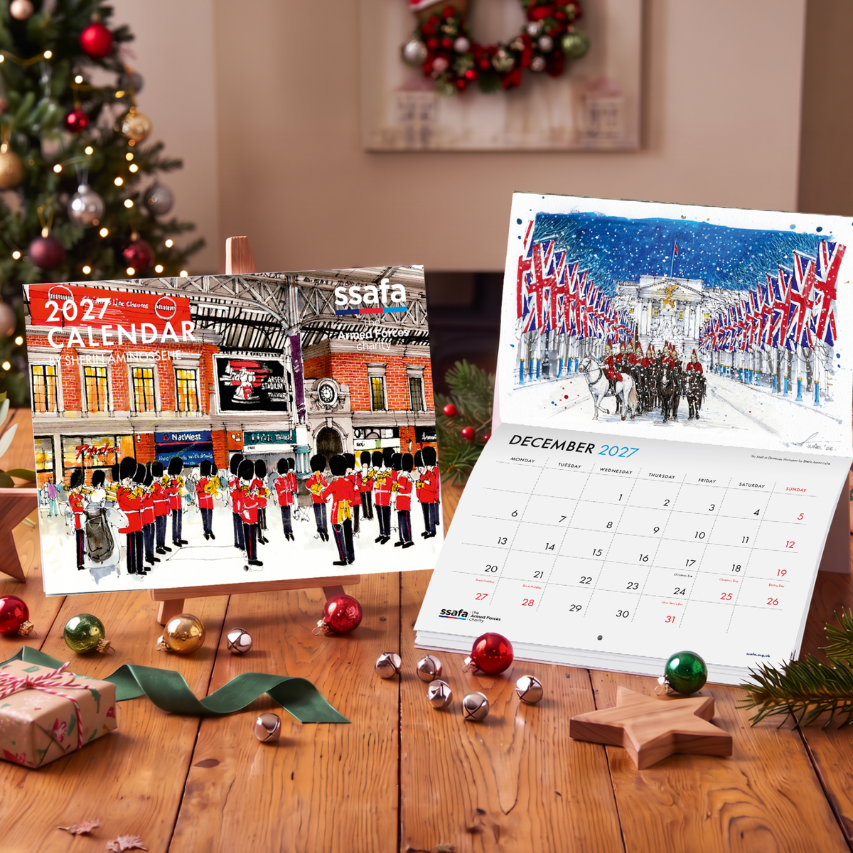 SSAFA Calendar on wooden table with Christmas decorations on table and Christmas tree in the background.