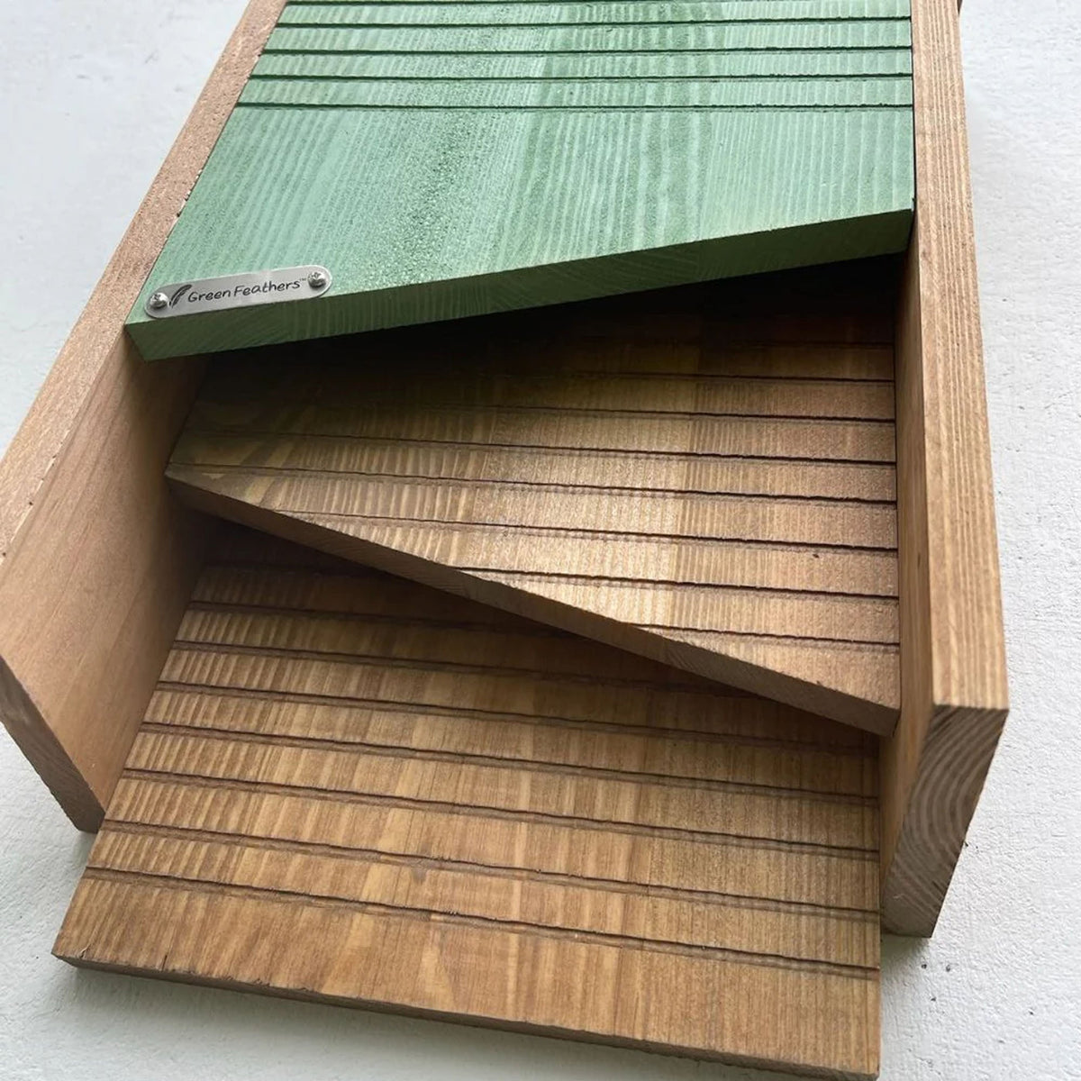 Wooden bat box with green top and brown sides on a white background