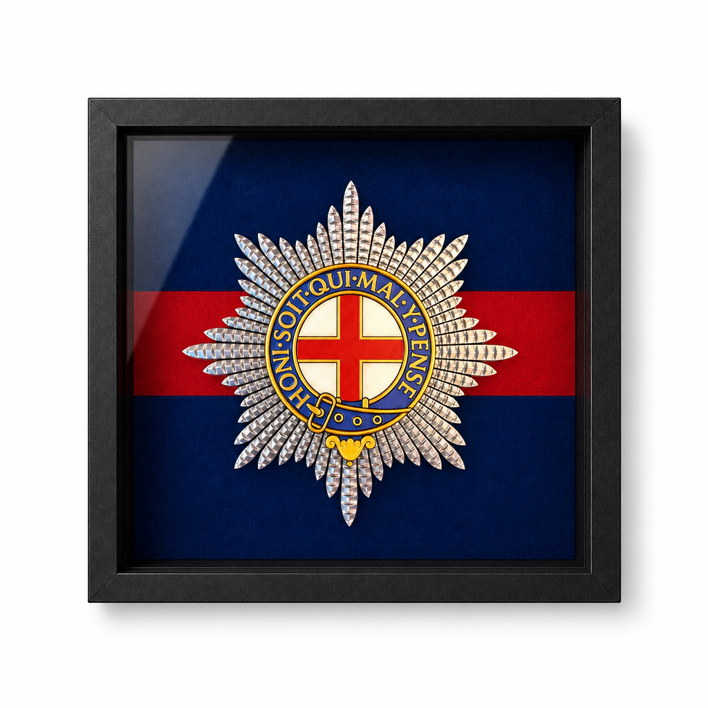 A black framed military Coldstream Guards cap badge, displayed against a professionally pigment-printed Coldstream Guards backing, in a black shadowbox frame.