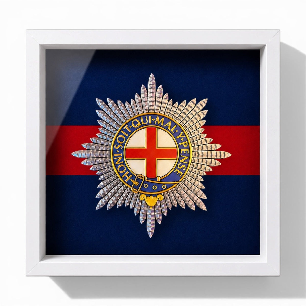 A framed military Coldstream Guards cap badge, displayed against a professionally pigment-printed Coldstream Guards backing, in a white shadowbox frame.