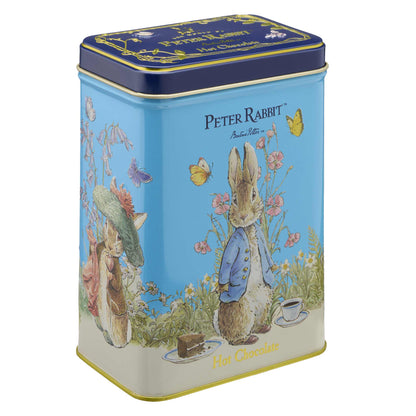 A Peter Rabbit themed hot chocolate tin with a light blue body, dark blue lid, and illustrations of Peter Rabbit, Beatrix Potter characters, and butterflies on a white background.