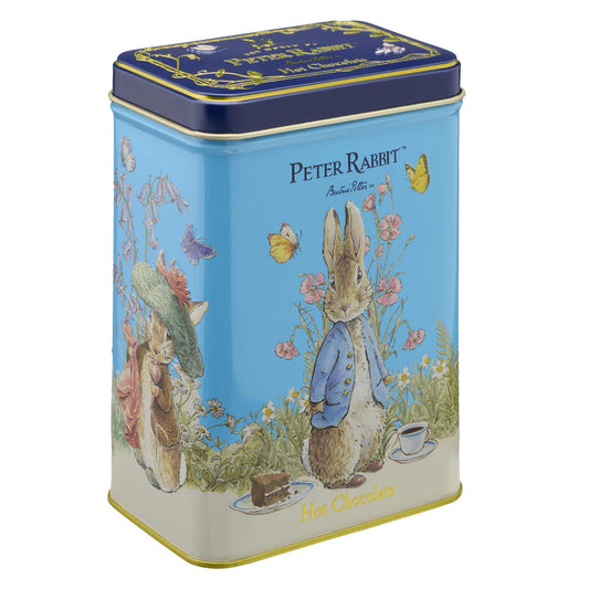 A Peter Rabbit themed hot chocolate tin with a light blue body, dark blue lid, and illustrations of Peter Rabbit, Beatrix Potter characters, and butterflies on a white background.