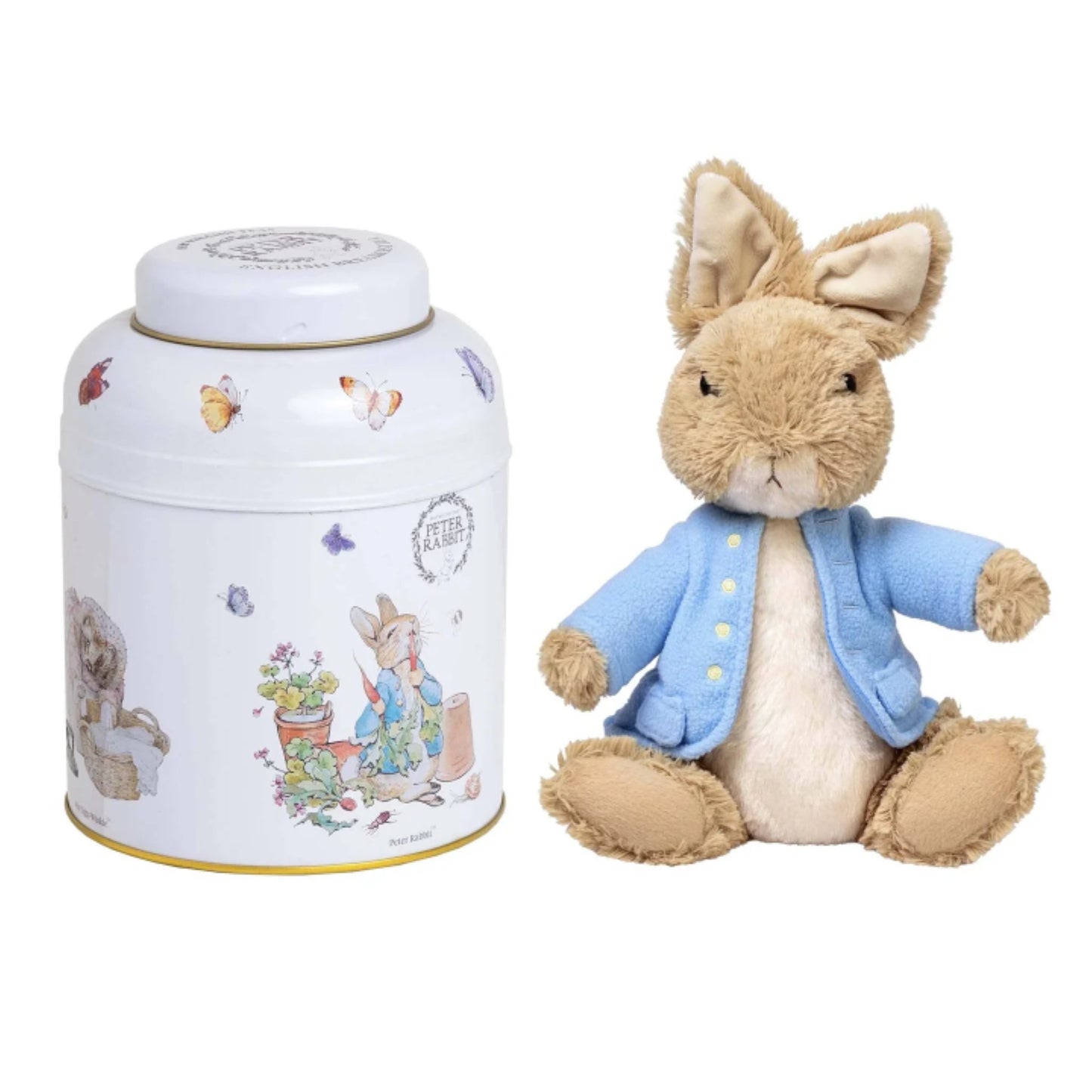 A Peter Rabbit collectible set featuring a plush toy Peter Rabbit in a blue jacket next to a white metal tin decorated with Peter Rabbit illustrations.