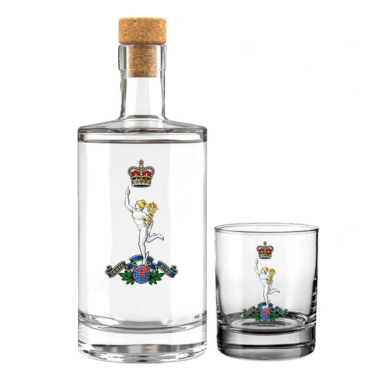A clear glass bottle with a cork stopper and a matching clear glass tumbler, both printed with Royal Corps of Signals insignia, on a white background.