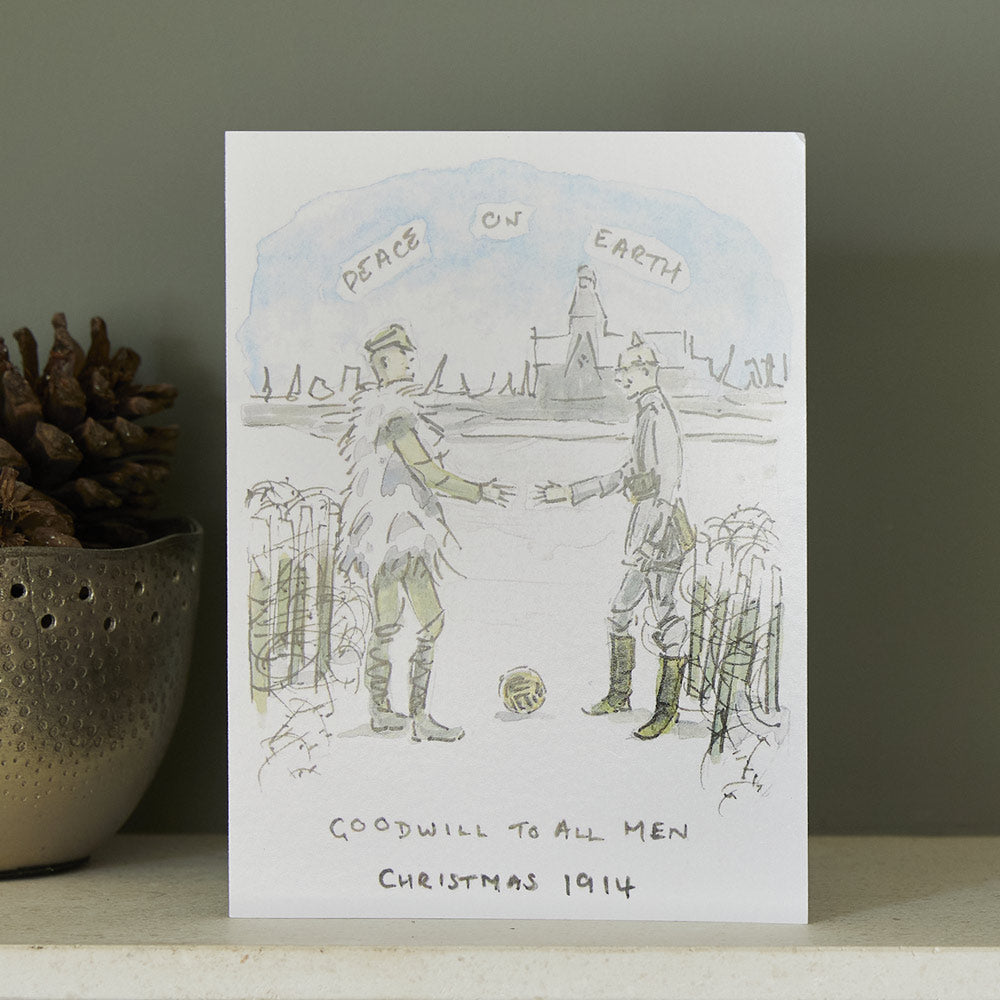Christmas card with soldiers shaking hands and 'Peace on Earth' text, placed on a surface with a dark background.