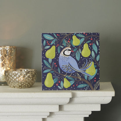 Decorative box with Partridge and Pear Tree design on a mantel piece with Christmas decorations