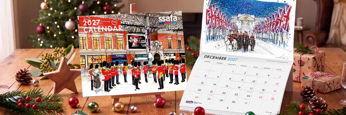 SSAFA Calendar on wooden table with Christmas decorations on table and Christmas tree in the background.